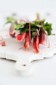 Stems of rhubarb on a white chopping board