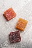 Three cubes of fruit jelly covered in sugar