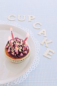 A cupcake for a birthday with letters spelling out the word 'cupcake'
