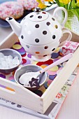 Polka-dot teapot and cup set on tray decorated with confetti