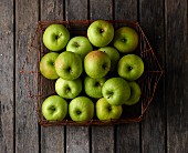Granny Smith apples in a wire basket (seen from above)