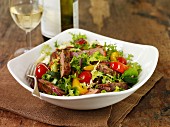 A colourful salad with beef steak