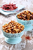 Spicy roasted cashew nuts and Brazil nuts in light blue bowls