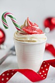 A Christmas cupcake decorated with a candy cane and peppermint buttercream