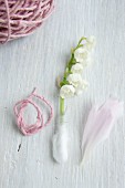 Lily-of-the-valley with stem wrapped in cotton wool, pink woollen yarn and peony petal