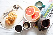 Breakfast with croissants, coffee, grapefruit and newspapers