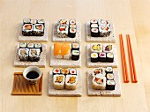 Various types of sushi, soy sauce and chopsticks