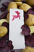 Kartofffeldruck - Papier mit gedrucktem Tiermotiv auf Kartoffeln und lila Kartoffelchips