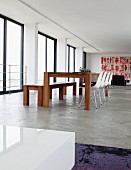 Modern dining area with bench and Eames shell chairs on polished concrete floor in Johannesburg art collector's loft apartment