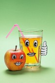 Apfelgesicht und ein Glas Apfelsaft mit Gesicht