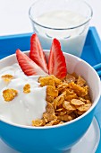 Cornflakes with strawberries and a glass of milk