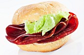 A bread roll filled with smoked beef and lettuce