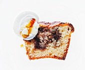 A slice of vanilla cake with nuts, raisins, cinnamon, cream and maple syrup