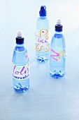 Three bottles of water with name tags