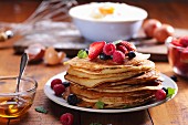 Pancakes with fresh summer berries and mint leaves
