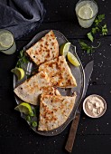 Quesadillas with a dip and limes