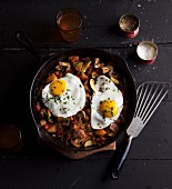 Fried potatoes with fried eggs in a pan