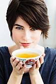 A woman holding a bowl of tea