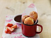 Mini doughnuts in a cup, fresh strawberries and chocolate sauce