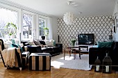 Scandinavian, designer pendant lamps and wallpaper with Oriental ogee pattern in living room furnished in black and white