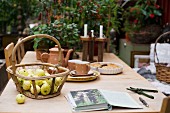 Basket of apples and rustic coffee service on wooden table
