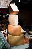 A stack of Parmesan cheese on a market stall