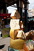 A stack of Parmesan cheese on a market stall