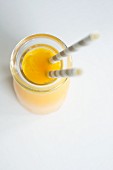 A bottle of orange juice with straws