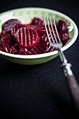 Pickled beetroot in a bowl with a fork