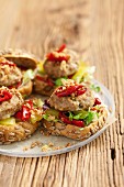 Burgers topped with marinated peppers and gherkins