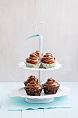 Cupcakes topped with chocolate buttercream on a cake stand