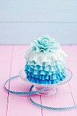 A mini cake decorated with blue icing