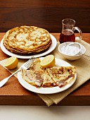 Crepes with lemon, icing sugar and maple syrup