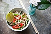 Fried noodles with vegetables, chilli peppers, five spice powder and limes (Asia)