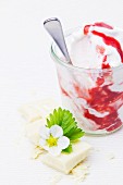 Frozen yogurt with strawberry sauce, white chocolate and a strawberry flower