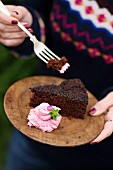 A woman eating a slice of beetroot cake with beetroot cream cheese