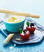 Tomatoes filled with cream cheese and olives, and lemon cream with grissini