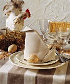 Gedeckter Tisch fürs Osterfest dekoriert mit Hühnerfigur & bemalten Eiern