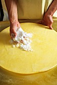 Käselaib wird mit Salz eingerieben (Bregenzerwald, Vorarlberg, Österreich)