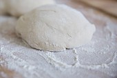 Pizza dough on a floured wooden board
