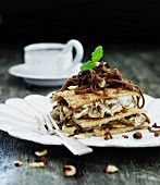 A layered dessert with nut cream, prunes and grated chocolate
