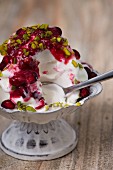 Frozen yogurt with chopped pistachios and pomegranate seeds with a bite taken out