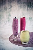 Various fruit smoothies (raspberry, blueberry and apple) in glasses