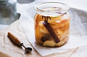Apple compote with a cinnamon stick and cloves in a glass jar