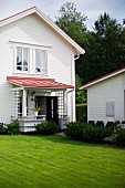 View from garden to white clapboard house with porch