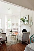 View from dining room through wide, open doorway into living room with elegant period furniture and fireplace in rustic interior