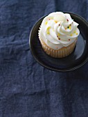 A vanilla cupcake decorated with colourful sprinkles