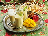 Three glasses of mango lassi on a tray