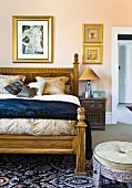 Elegant double bed with carved wooden frame and Oriental-style stool in bedroom