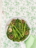 Fried mushrooms with green asparagus, peas and mange tout